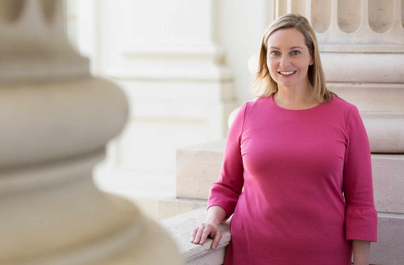 Photograph of Parker Hamilton Poling &rsquo;99 standing beside a marble column